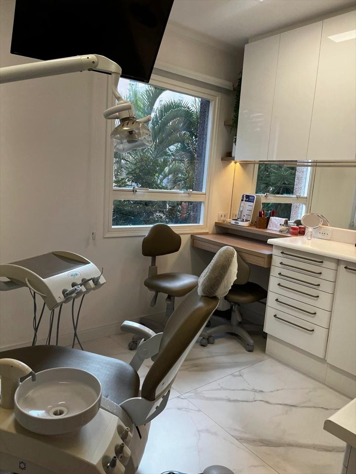 Sala de atendimento com cadeira odontológica e janela para o jardim